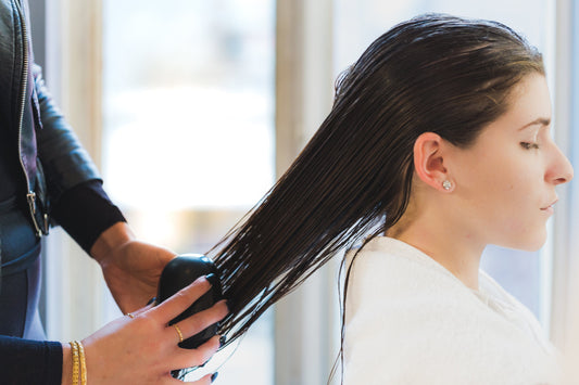 Stylist working a lightening treatment through a client's hair at a salon